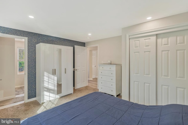 unfurnished bedroom with light colored carpet and a closet