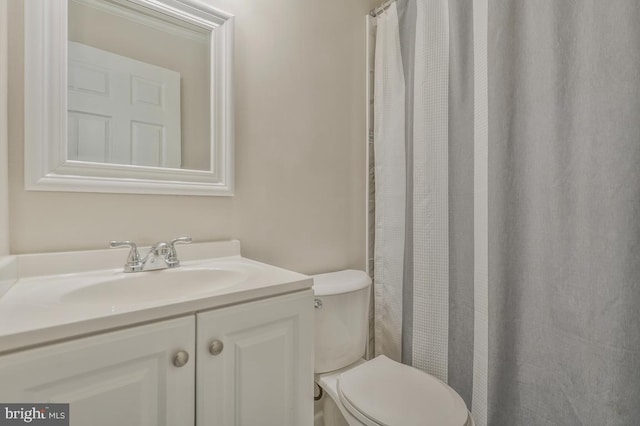 bathroom with crown molding, vanity, and toilet