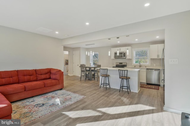 living room with light hardwood / wood-style floors and sink