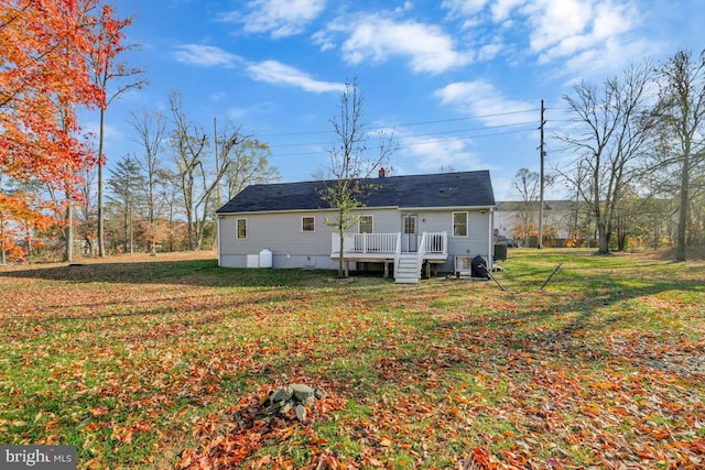 rear view of property featuring a lawn and a wooden deck