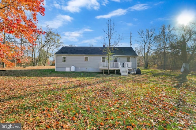 back of property with a yard and a wooden deck