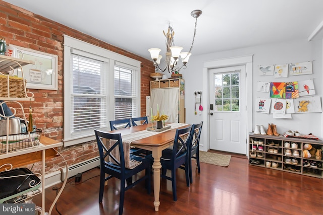 dining area with dark hardwood / wood-style flooring, an inviting chandelier, and brick wall