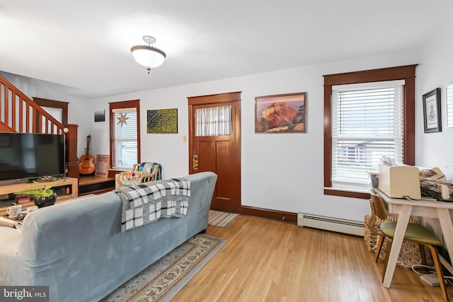 living room with light wood-type flooring and a baseboard heating unit