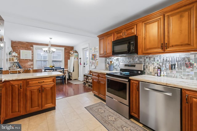 kitchen featuring appliances with stainless steel finishes, backsplash, light hardwood / wood-style flooring, a notable chandelier, and pendant lighting