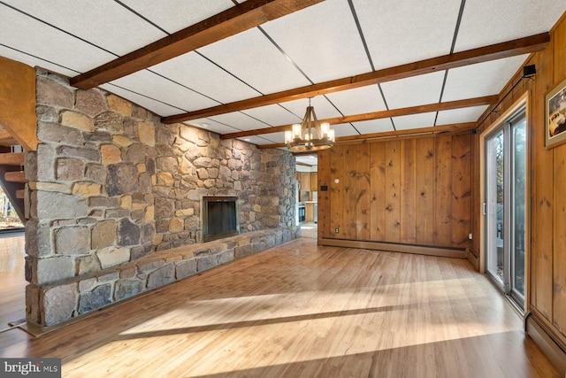 unfurnished living room featuring wood walls, light hardwood / wood-style flooring, and baseboard heating