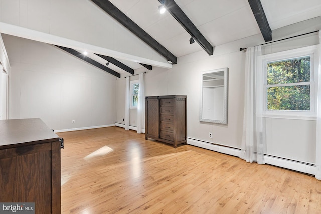 interior space featuring light wood-type flooring, a healthy amount of sunlight, a baseboard heating unit, and vaulted ceiling with beams