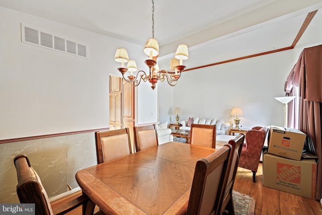 dining room featuring wood-type flooring and an inviting chandelier