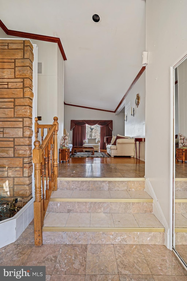 stairway featuring ornamental molding and high vaulted ceiling