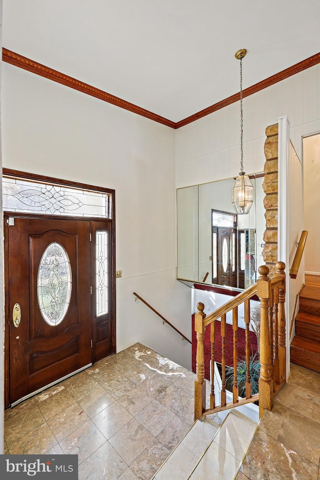 entryway featuring crown molding and a notable chandelier