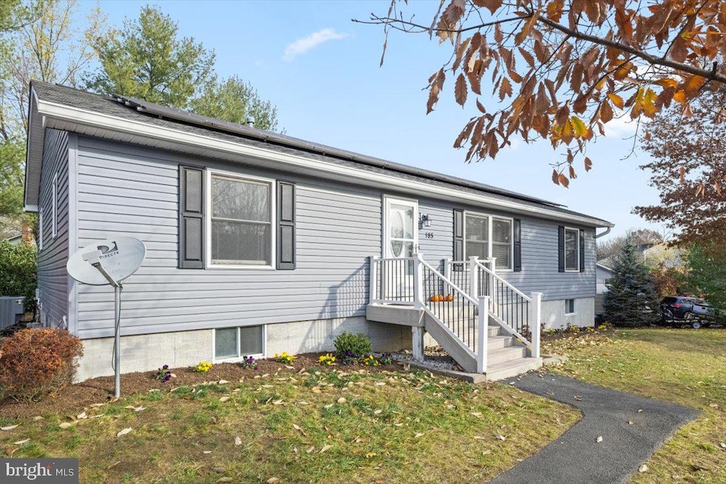 view of front of property with a front yard and cooling unit