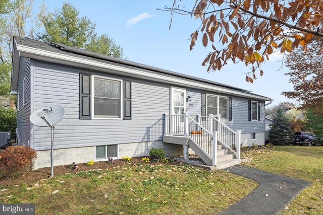 view of front of property with a front yard and cooling unit