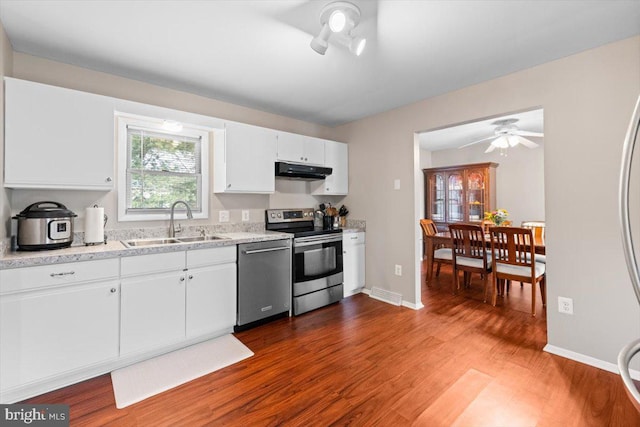 kitchen featuring wood-type flooring, sink, ceiling fan, appliances with stainless steel finishes, and white cabinetry