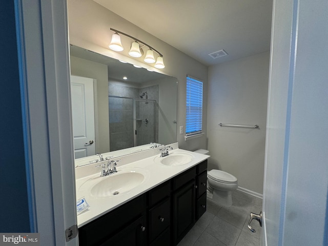 bathroom featuring toilet, vanity, tile patterned floors, and an enclosed shower