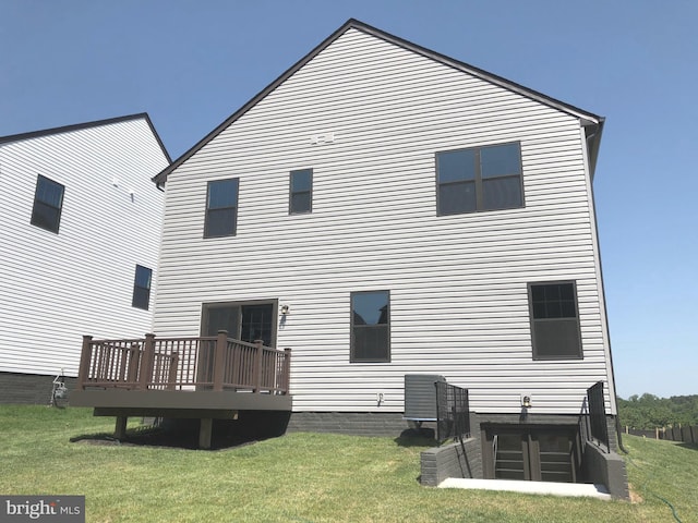back of house with a wooden deck and a yard