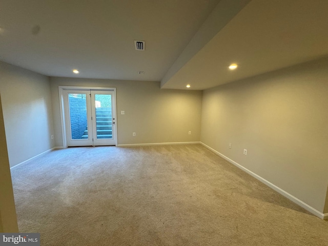 empty room with french doors and light colored carpet