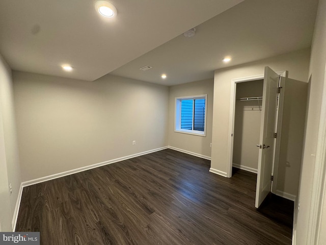 unfurnished bedroom with dark wood-type flooring and a closet