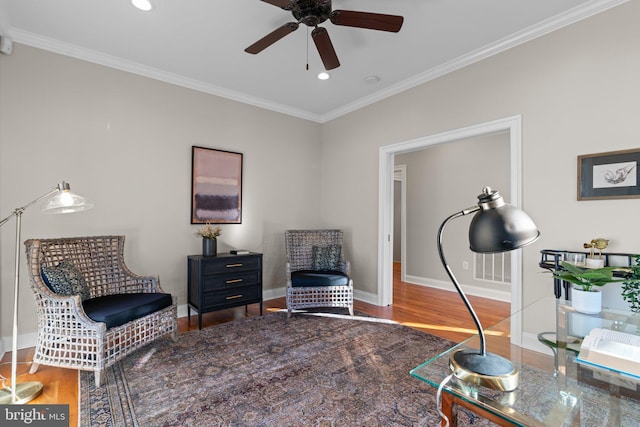 sitting room with wood-type flooring, ceiling fan, and crown molding