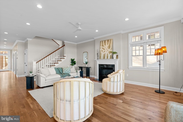 living room featuring hardwood / wood-style flooring, plenty of natural light, ceiling fan, and ornamental molding