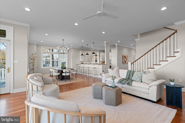 living room featuring light wood-type flooring, plenty of natural light, and crown molding