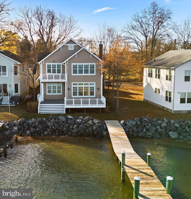 rear view of house featuring a balcony and a water view