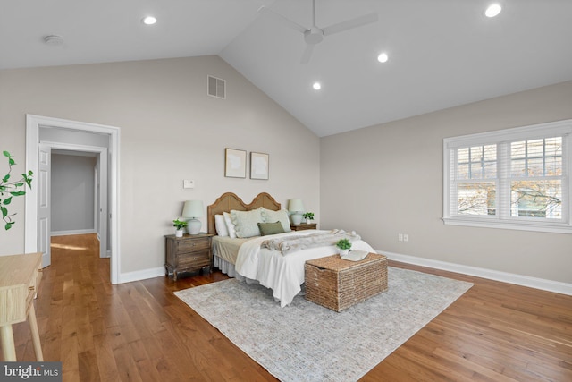 bedroom featuring ceiling fan, hardwood / wood-style floors, and high vaulted ceiling