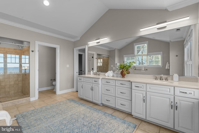 bathroom featuring tile patterned flooring, a tile shower, and vanity