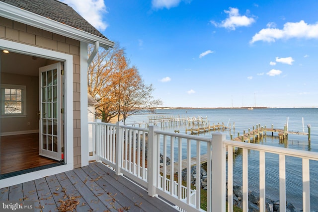 wooden deck with a boat dock and a water view