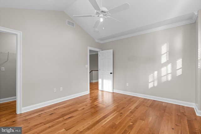 unfurnished bedroom with a spacious closet, ceiling fan, lofted ceiling, a closet, and hardwood / wood-style flooring