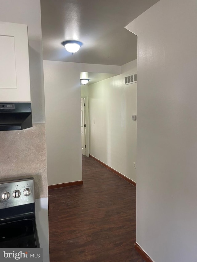 kitchen with visible vents, dark wood finished floors, stainless steel electric range oven, ventilation hood, and white cabinetry