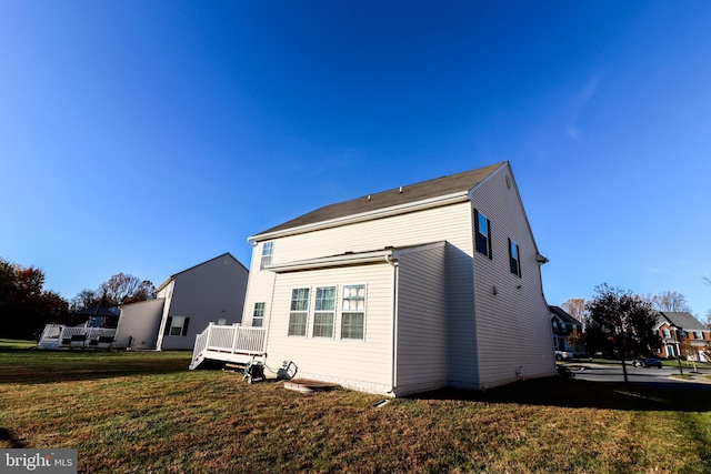 rear view of house featuring a yard and a deck