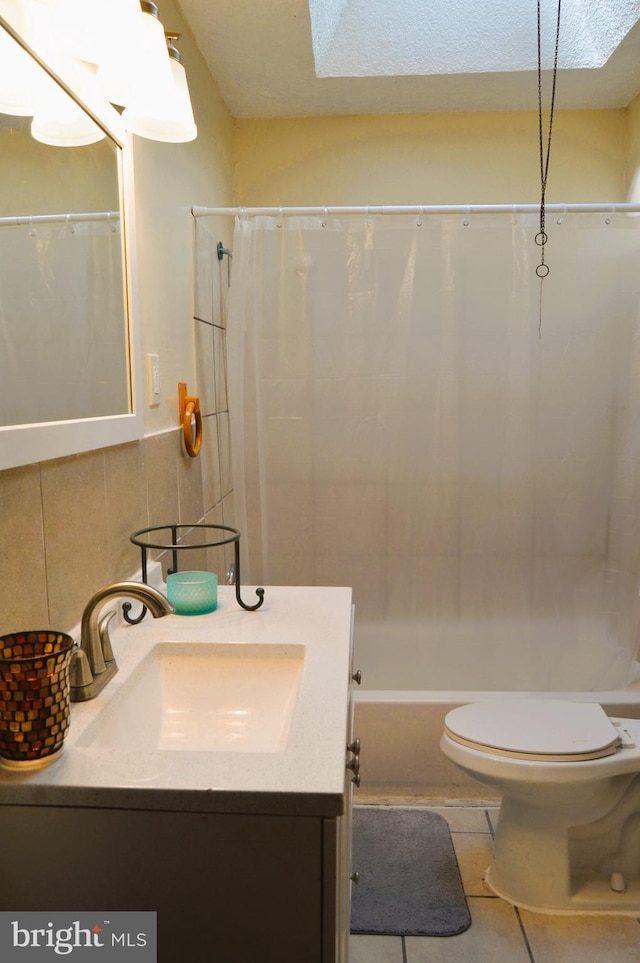 full bathroom with shower / tub combo, toilet, tile walls, vanity, and tile patterned flooring