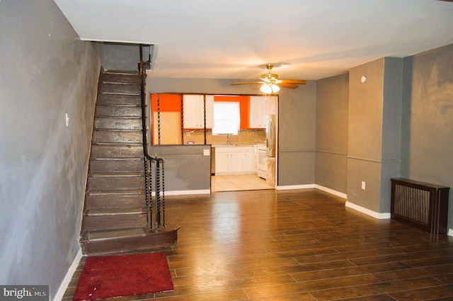 unfurnished living room with ceiling fan, hardwood / wood-style flooring, and sink