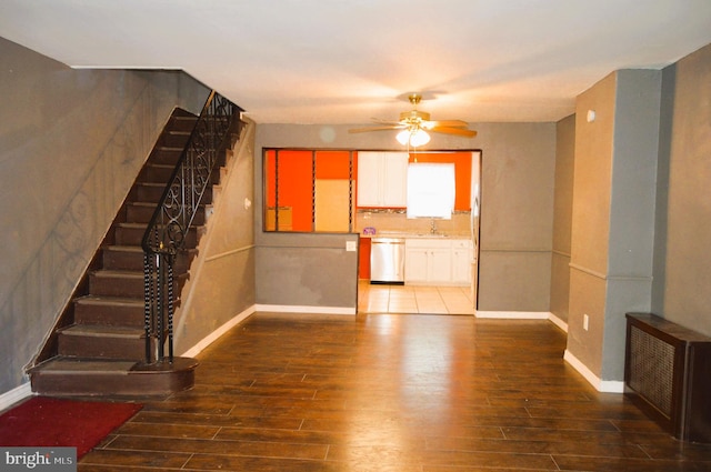 unfurnished living room with ceiling fan, sink, and hardwood / wood-style floors