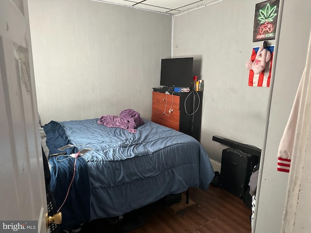 bedroom featuring wood-type flooring and wooden walls