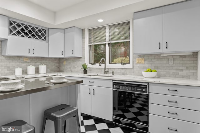 kitchen featuring backsplash, dishwasher, white cabinets, and sink