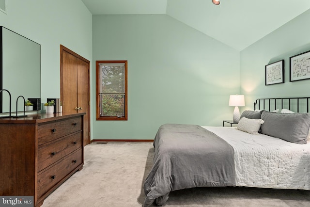 bedroom with light colored carpet and vaulted ceiling