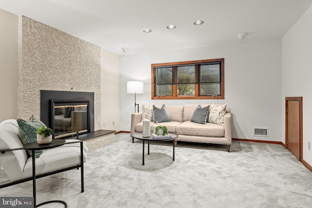 living room featuring a fireplace and light carpet