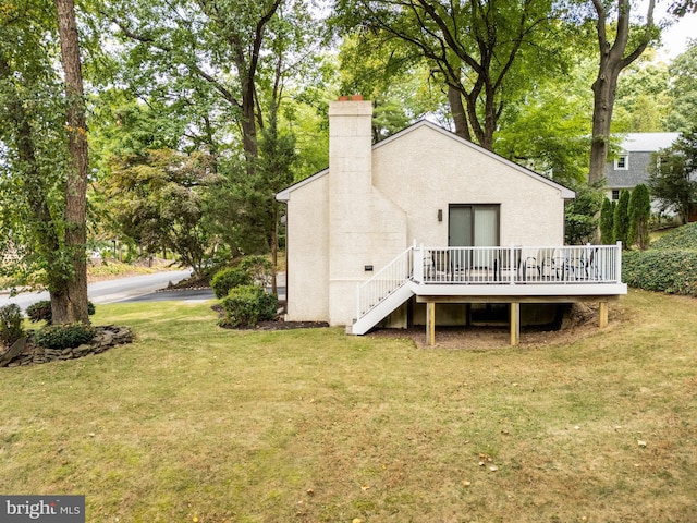 back of house featuring a yard and a wooden deck