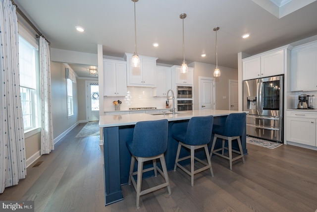 kitchen with tasteful backsplash, stainless steel appliances, pendant lighting, white cabinets, and dark hardwood / wood-style floors