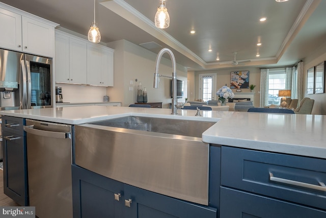 kitchen featuring a raised ceiling, white cabinetry, crown molding, and blue cabinets