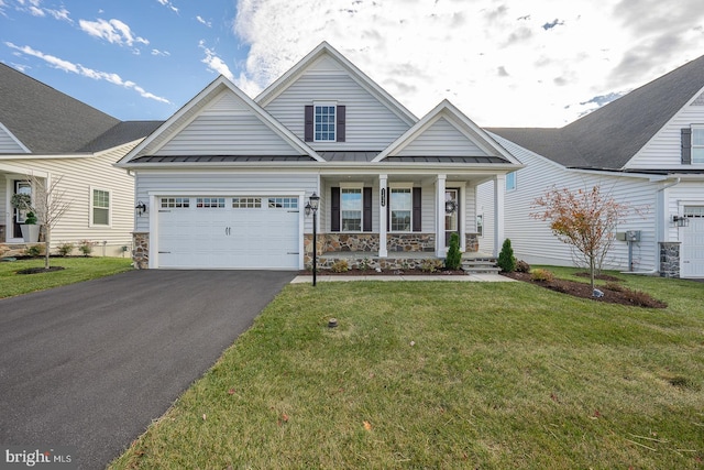 view of front of home featuring covered porch, a front yard, and a garage