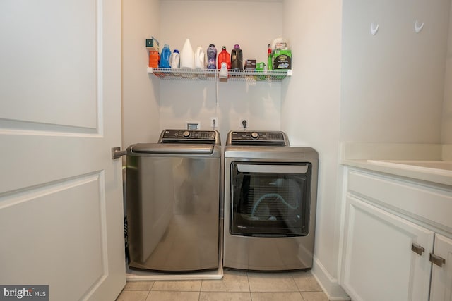 laundry area featuring washer and dryer and light tile patterned floors