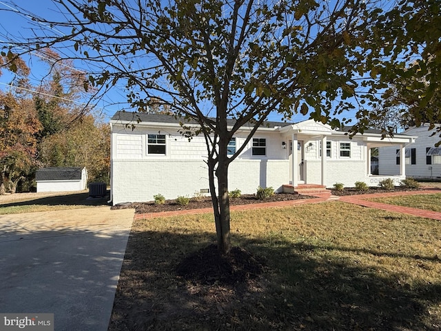 view of front of house with a front lawn and central air condition unit