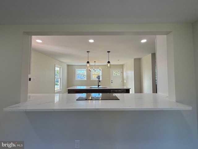 kitchen featuring black electric cooktop, kitchen peninsula, sink, and pendant lighting