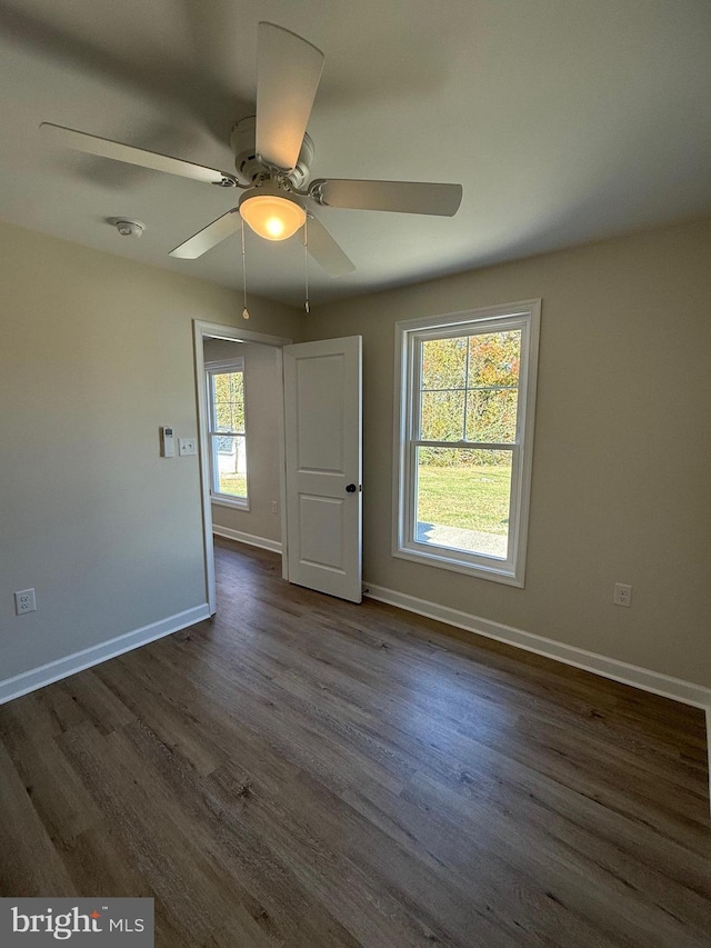 unfurnished room featuring ceiling fan and dark hardwood / wood-style flooring