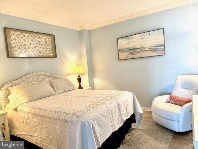 bedroom with hardwood / wood-style floors and crown molding