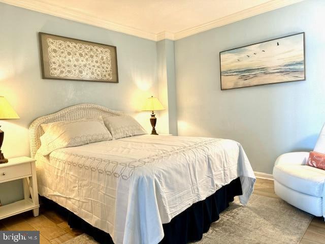 bedroom featuring hardwood / wood-style flooring and ornamental molding