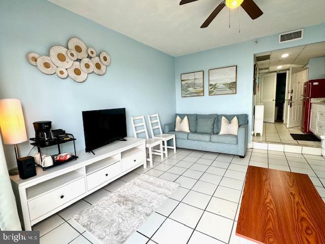 tiled living room with ceiling fan