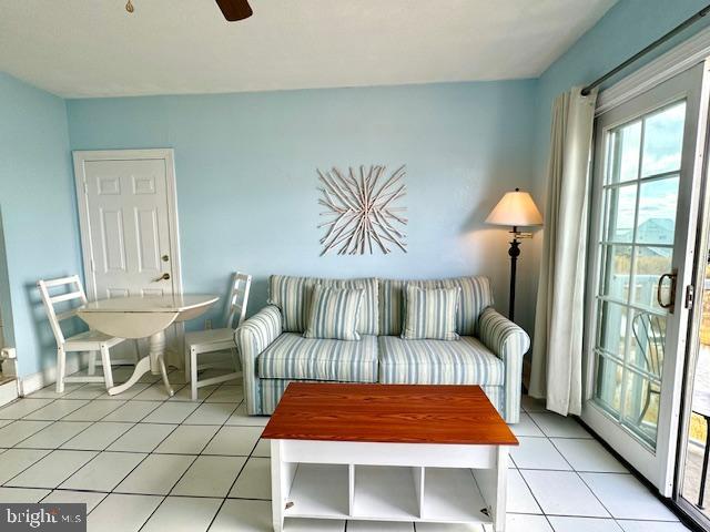 living area with light tile patterned floors and ceiling fan