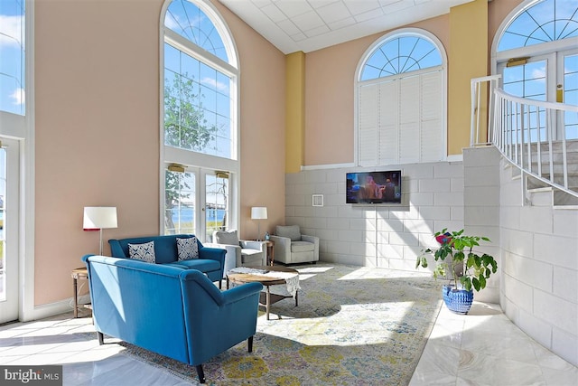 living room featuring tile walls, french doors, and a wealth of natural light